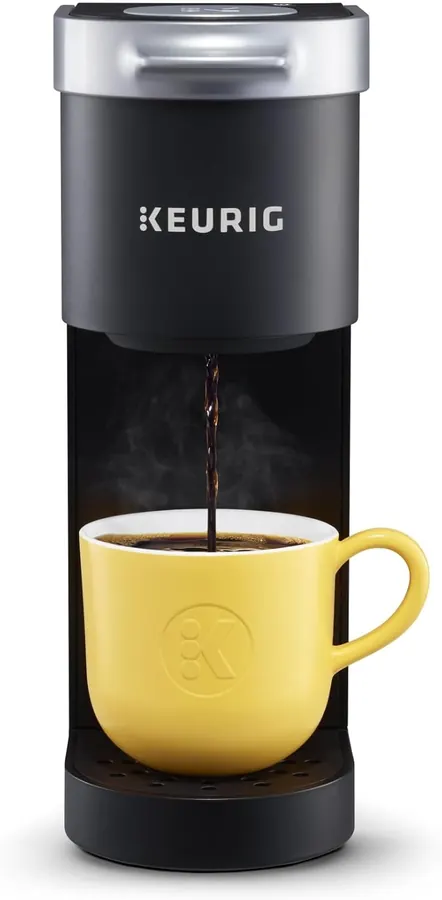 Hand placing a K-Cup pod into the open top of a single-serve coffee maker